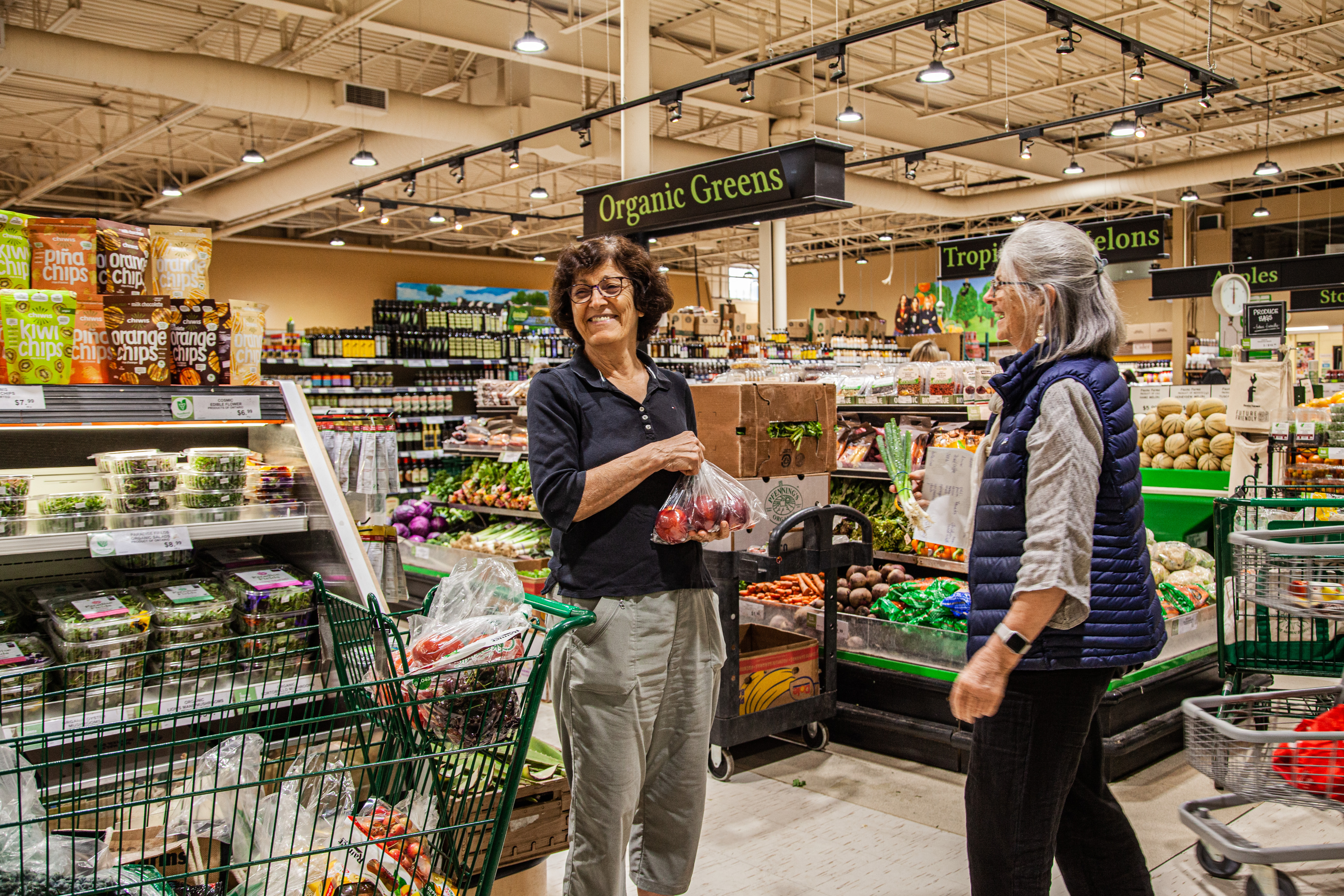 Two Fiesta team members chatting in the grocery aisle